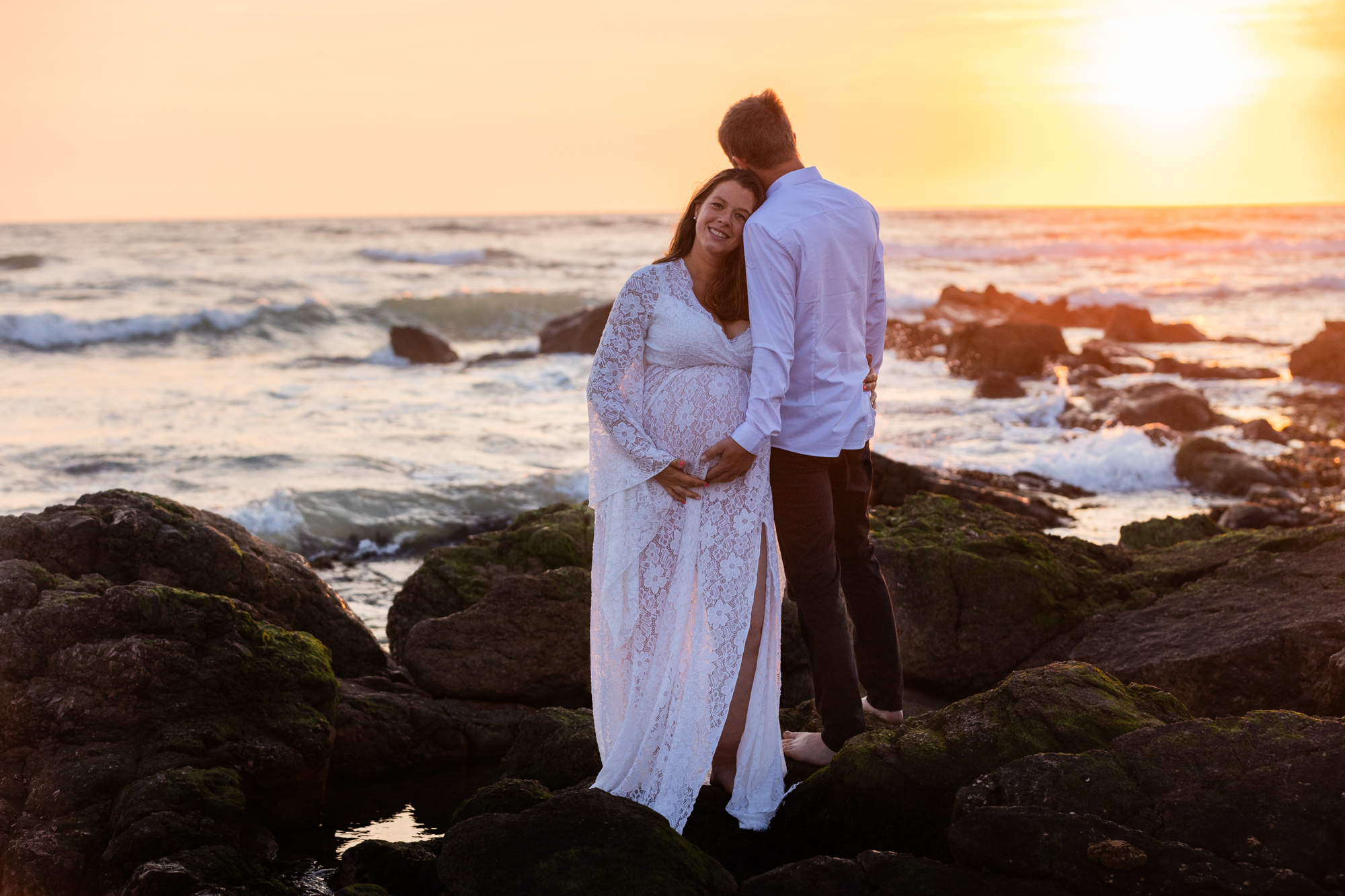 Photographie immortalisant une grossesse à la plage au coucher de soleil